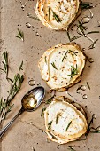 Slices of celeriac topped with melted goat's cheese and garnished with rosemary and acacia honey