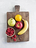Various types of fruit on a wooden board (seen from above)