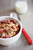 A bowl of muesli and a bottle of milk