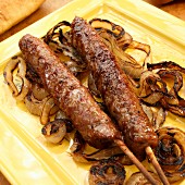 Grilled Italian pork sausage on skewers with caramelised onions