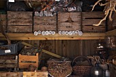 Baskets and old wooden boxes filled with pine cones on a shelf in a storage shed