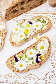 Slices of bread topped with daisies and tufted pansies