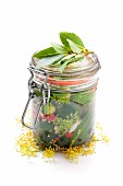 A jar of homemade gherkins with dill flowers and bay leaves