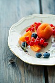 A fruit platter with apricots, blueberries and redcurrants