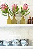 Decorative flowers and bowls on a wall shelf