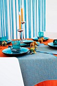 Table set with blue crockery, small elephant and other animal figurines and candlesticks