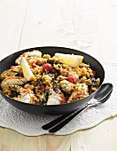 Paella with chicken, fish and tomatoes