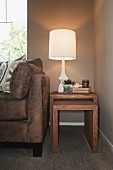 Lit table lamp with cropped couch in the living room