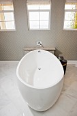 Zeitgenössisches Badezimmer mit ovaler freistehender Badewanne in Weiß