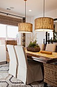 Chairs at dining table below round pendant lamps; Moreno Valley; California;