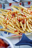 French fries with tomato ketchup on a colourful plate