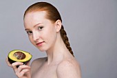 A portrait of a young woman holding an avocado