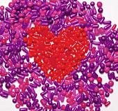 Violette Bonbons, in der Mitte Herz aus roten Bonbons geformt