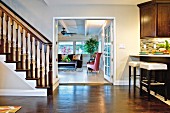 Living room with kitchen counter, open staircase and French doors to living room