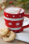 Hot chocolate in a red and white cup served with white chocolate biscuits