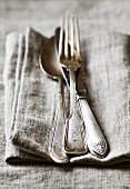 Old silver cutlery on a linen cloth