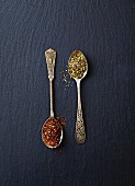 Dried green and red rooibos tea on spoons