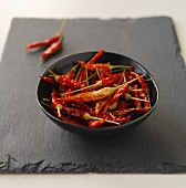 Dried red chillis in a black bowl