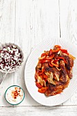 Roast chicken legs with peppers and onions served with a side of rice