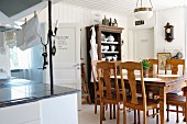 Dining area with chairs and Wilhelmine-era table below vintage, pendant lamp in rustic kitchen