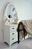 Crocheted blanket draped over foot of bed, vintage, white dressing table with oval mirror