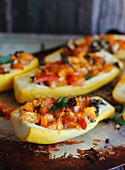 Yellow squash filled with vegetables on a baking tray