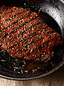 A grilled steak in a pan (close-up)