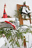 Festive arrangement with Welcome sign outside house with figurines, lanterns, ice skates and fir branches