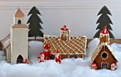 Wooden model of Swedish church, gingerbread houses and Father Christmas figurines in artificial snow