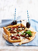 Caramelised onion tarts with salami and feta cheese