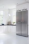 Black and white Scandinavian, country-house kitchen with side-by-side, stainless steel fridge-freezer