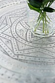 Flower stems in glass vase on ornate, Oriental metal tray