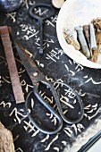 Traditional bonsai shears and small objects on stone slab engraves with Japanese characters