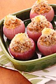 Stuffed red onions with a cheese topping in a baking dish