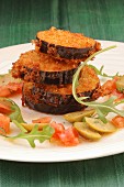 Breaded aubergines with olives and tomatoes