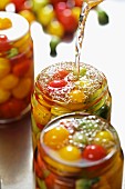 Tomatoes being preserved in jars