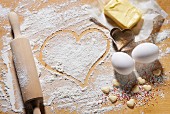 Various baking ingredients, a rolling pin and heart-shaped cutters
