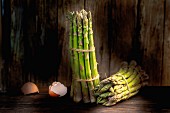 Bunches of green asparagus and eggshells