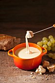 Cheese fondue with bread and grapes