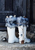 weiße Gummistiefel mit Fellrand und Christbaumschmuck als alternativer Nikolausstiefel