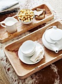 White tea set on wooden trays on ottoman with cowhide cover