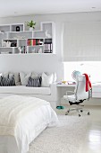 Built-in desk, couch and decorative wall shelves in white, teenager's bedroom