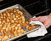 Croutons being removed from an oven