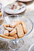 Sponge fingers with icing sugar in a glass bowl