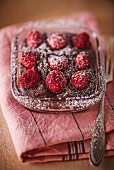 Chocolate cake with raspberries and icing sugar