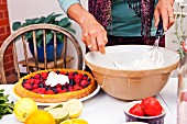 A woman preparing a fruit flan at a garden party