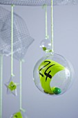 Number on green paper inside suspended plastic bauble