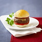 A mini beefburger with ketchup