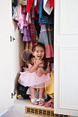 Girl in princess costume hiding in wardrobe