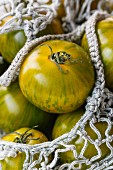 Green tomatoes in a shopping net (close-up)